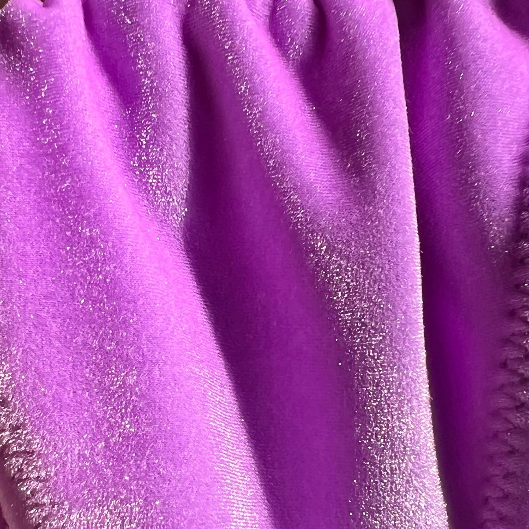 Close up photo of the Temptress, a purple velvet bikini from Baddie Beach Fantasy Collection, showcasing the iridescence of the fabric in the sun.